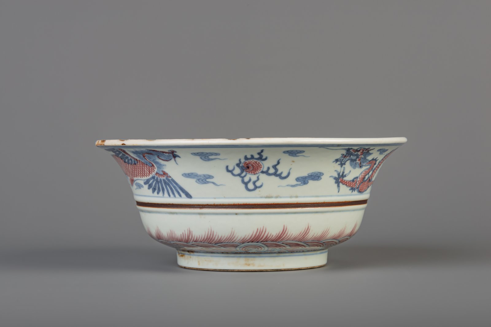 A Chinese blue, white and copper red 'dragon and phoenix' bowl, Kangxi mark, 19th/20th C. - Image 5 of 8