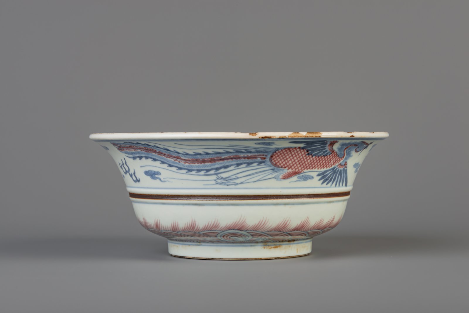 A Chinese blue, white and copper red 'dragon and phoenix' bowl, Kangxi mark, 19th/20th C. - Image 4 of 8