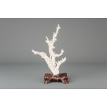 A Chinese carved white coral group on a wooden stand, Republic, 20th C.