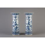 A pair of Chinese blue and white cylindrical vases with floral design and animals, 19th C.