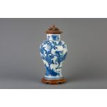 A Chinese blue and white 'kylin' vase with wooden cover and stand, 19th C.