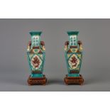 A pair of Chinese dragon relief decorated vases on wooden bases, Republic, early 20th C.