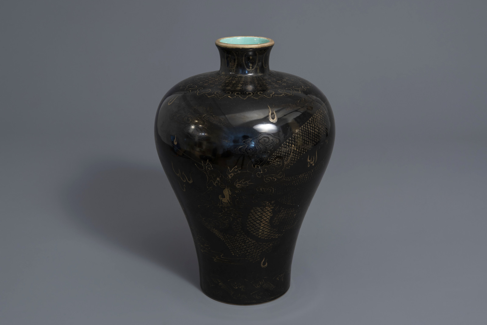 A Chinese black ground vase with a gilt dragon chasing the pearl, Qianlong mark, 19th C.