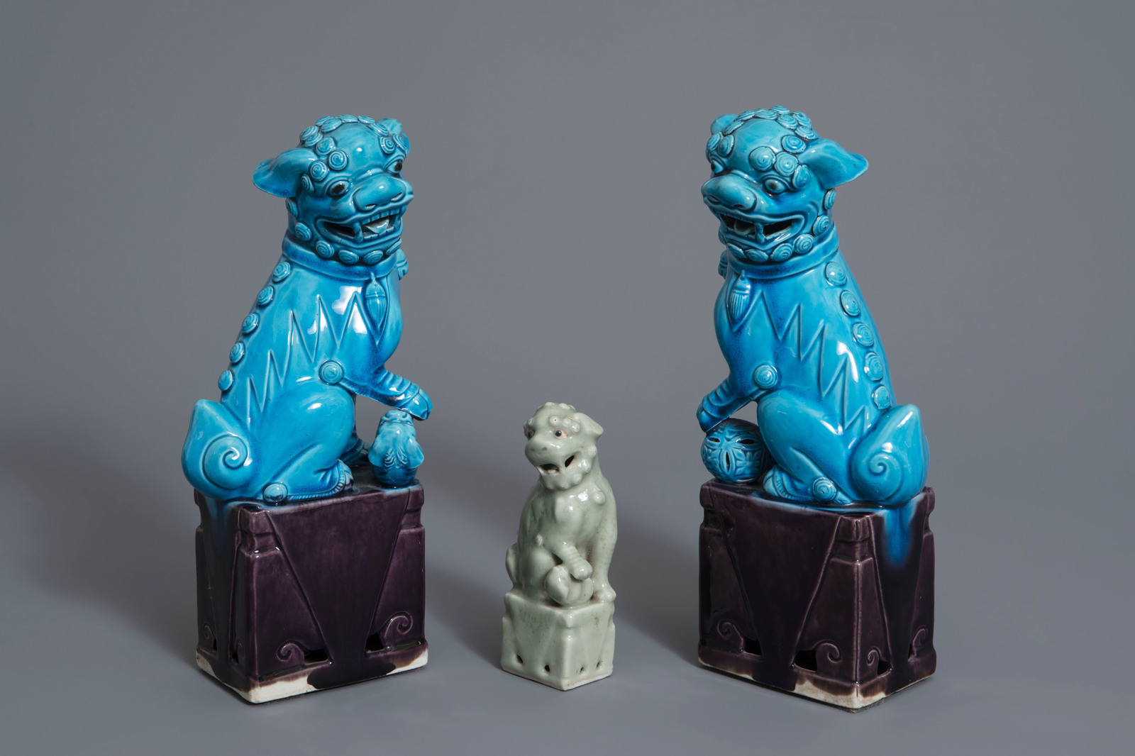 A pair of Chinese turquoise glazed models of Buddhist lions and one in celadon, 19th/20th C.