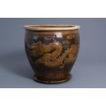 A large Chinese brown glazed stoneware jardinire on stand w. a dragon, 19th/20th C.