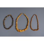 Three Chinese amber necklaces, including butterscotch, 19th/20th C.