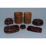 Two Chinese carved bamboo brush pots and five wooden stands, 19th/20th C.