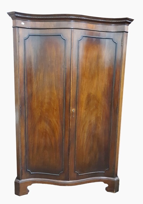 Georgian style mahogany serpentine-front wardrobe with dentil cornice, the pair of panelled doors