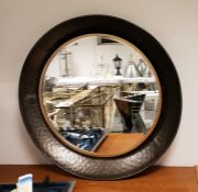 Circular wall mirror with bevelled plate, within a mottled metal frame, diameter 88cm (VAT payable
