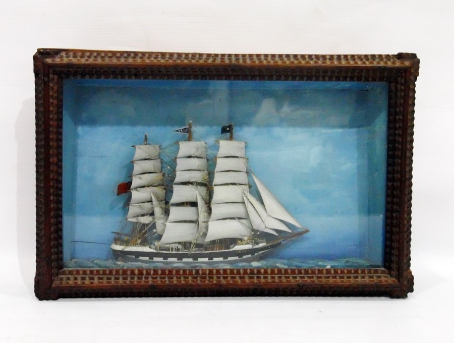 Model of a three-masted sailing ship in a wooden framed glass case