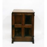 Reproduction oak side cupboard, the four-panelled door enclosing shelves, on shaped block feet,