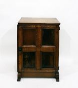 Reproduction oak side cupboard, the four-panelled door enclosing shelves, on shaped block feet,
