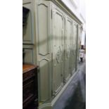 French style four-door wardrobe enclosing hanging space, the doors with scroll work panels, on a