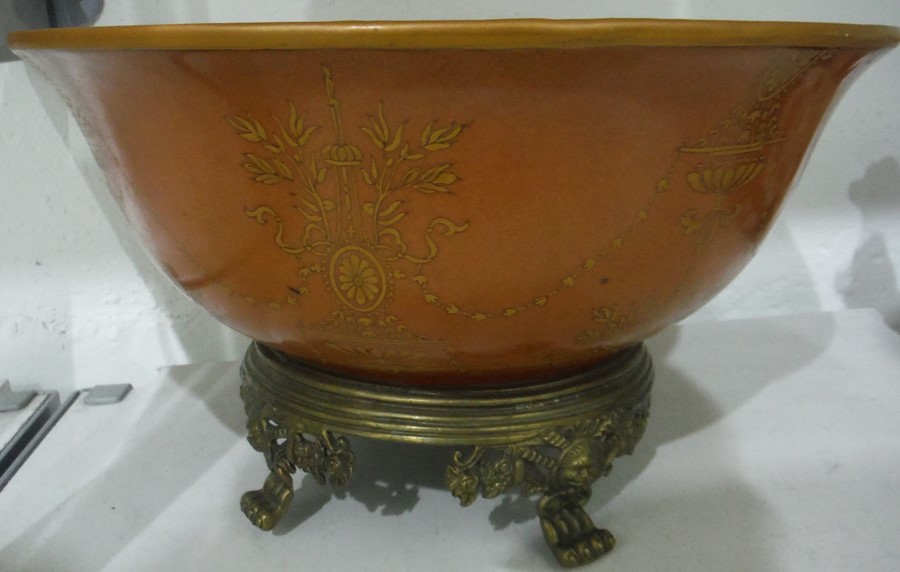 Orange ground bowl decorated with swag foliate repeating pattern, the bowl raised upon a brass