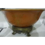Orange ground bowl decorated with swag foliate repeating pattern, the bowl raised upon a brass