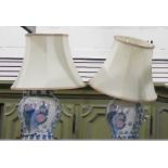 Two porcelain bodied table lamps in the form of lidded vases, the whole in the Chinese taste