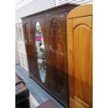 Edwardian sheraton-style mahogany triple wardrobe, the oval mirror plate central door flanked by