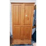 Modern pine wardrobe, the pair of fielded panelled doors enclosing hanging space, long drawer below,