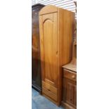 Modern pine single wardrobe, the arched panel door enclosing hanging space, with two short drawers