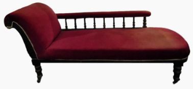 Late Victorian chaise longue with deep red upholstery, the scroll back with turned spindle
