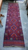 Meshwani wool runner with totem of lozenges in blue and red and having stylised crab border, 265 x