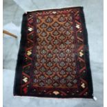 Small old Baluchi rug with graduated trellis work of allover stylised red and black plants on a