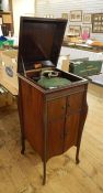 A Britanniaphone - a wind-up gramaphone in fitted cabinet with hinged lid and cupboards below.