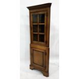 20th century oak corner display cabinet with glazed door enclosing three shelves, above cupboard