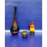 Art glass vase of bottle form with swirled yellow, red, orange, brown and metallic decoration,