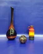 Art glass vase of bottle form with swirled yellow, red, orange, brown and metallic decoration,