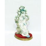 Lladro model of a geisha reclining against a bocage background and holding a fan, on oval base,