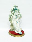 Lladro model of a geisha reclining against a bocage background and holding a fan, on oval base,