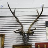 Wall-mounted carved wooden deer's head with large faux antlers (VAT payable on hammer)