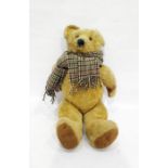 Large gold plush straw stuffed bear with glass eyes and stitched nose with a checkered scarf, height