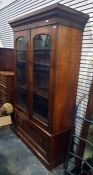 19th century mahogany bookcase with ogee moulded pediment above the two glazed doors, enclosing