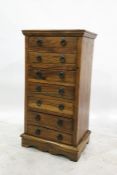 Eastern hardwood chest of seven short drawers each having metal drop ring handles and raised on