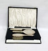 Four-piece silver-backed dressing table set comprising hand mirror, two brushes and a comb, with