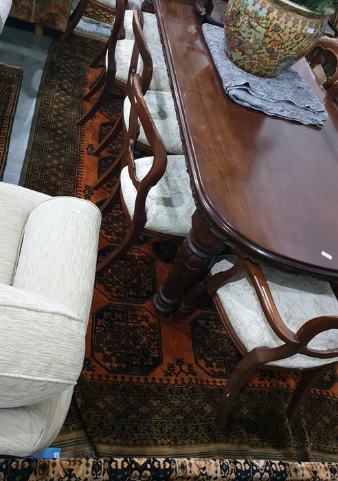 Burnt orange ground Eastern style floor rug, the central field decorated with elephant foot guls,