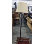 Turned mahogany standard lamp with cream shade