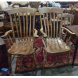 Two beech and elm seated slat-back carver chairs with turned front legs and stretchered bases (2)
