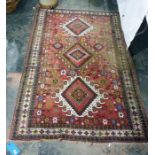 Caucasian style wool rug having three hooked lozenge shaped medallions to the cherry red field,