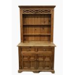 Pine dresser with moulded pediment above the shelves, the whole resting upon a base of two short