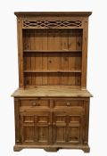 Pine dresser with moulded pediment above the shelves, the whole resting upon a base of two short