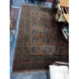 Large brown ground Eastern floor rug with four rows of six elephant foot gul medallions to the