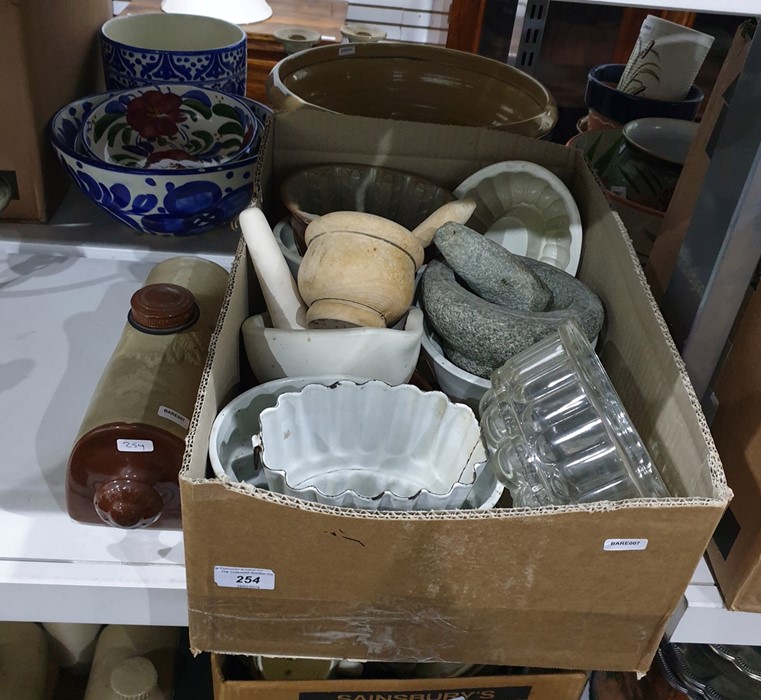 Box of various glass and ceramic jelly moulds and a wooden pestle and mortar