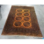Mustard ground Eastern style floor rug with elephant foot central medallions to a stepped border,