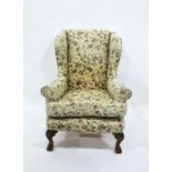 Wing armchair in floral weave, on ornate carved cabriole supports