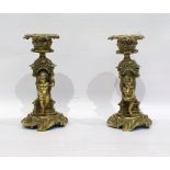 Pair of brass candlesticks, the stems modelled with seated children and on scrolling circular bases,