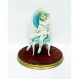 Lladro figure of a harlequin boy seated on a chair holding a cat, on circular base 27cm highNo