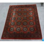 Eastern rug, the dark orange central field decorated with five rows of four elephant foot guls,